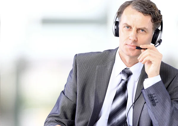 Businessman using headphones and smiling at office — Stock Photo, Image