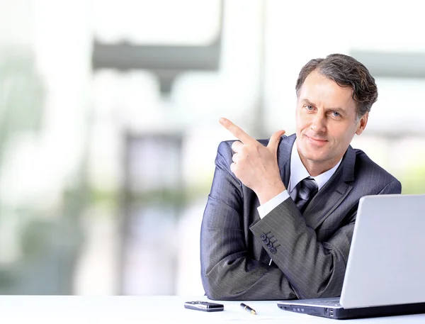 Homem de negócios agressivo com um laptop no escritório — Fotografia de Stock