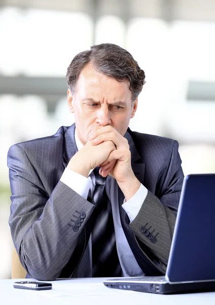 Tankeväckande affärsman tittar på sin laptop — Stockfoto