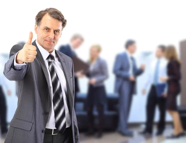 Succesvolle business man die met zijn personeel in de achtergrond op kantoor — Stockfoto