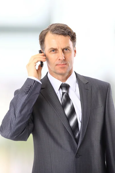 Mature executive man giving explanations and talking at phone mobile — Stock Photo, Image