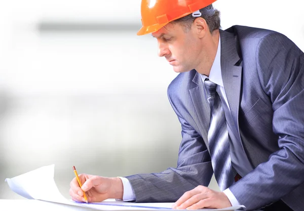 Bauleiter im Büro mit blauem Helm — Stockfoto