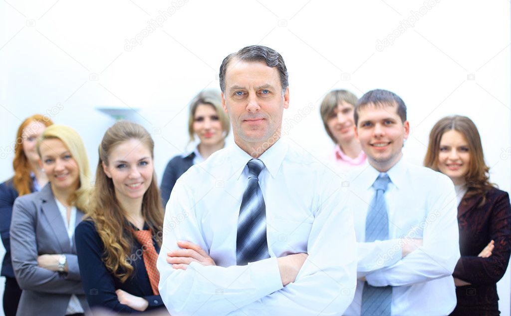Business man at the office with a group behind him
