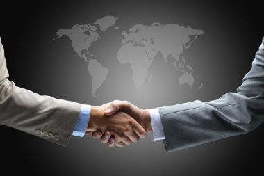 Handshake with map of the world in background clipart