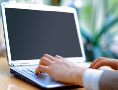 Person Typing on a modern laptop in an office clipart