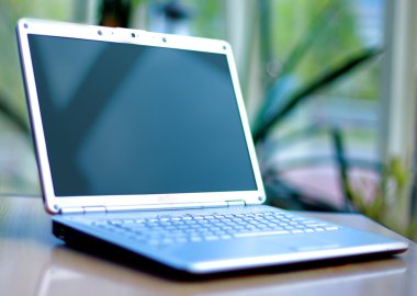 Thin laptop on office desk clipart