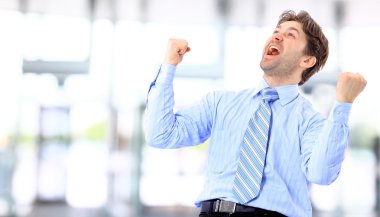 Portrait of an energetic businessman with his arms raised