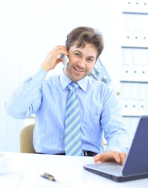 Knappe business man werkt op cellphone en laptop samen terwijl op wor — Stockfoto
