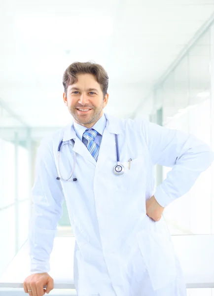 Happy smiling mature doctor writing on clipboard in a modern hospital — Stock Photo, Image