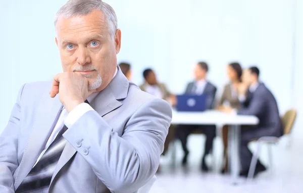 Porträtt av en senior business man deltar i en konferens med resten av h — Stockfoto