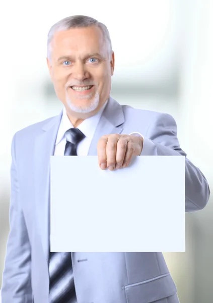 Porträt eines glücklichen, reifen Geschäftsmannes, der einen emty bill board gegen w zeigt — Stockfoto