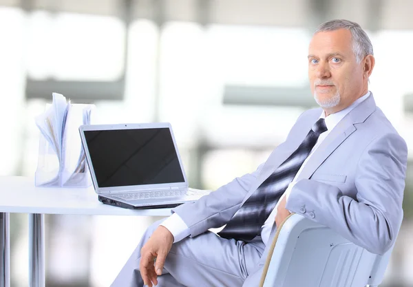 Portret van een gelukkig senior ondernemer weergeven computer laptop in kantoor — Stockfoto