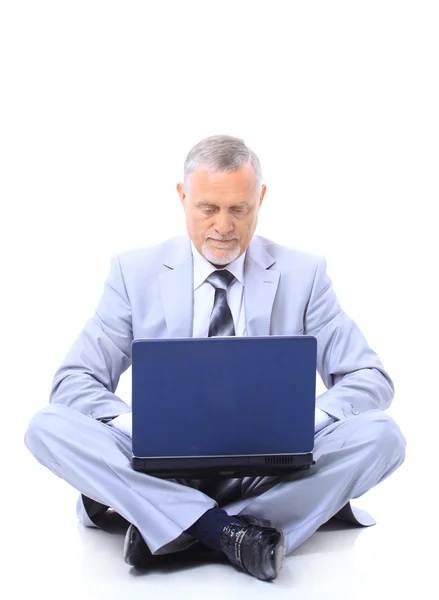 Ejecutivo sentado en el suelo con las piernas cruzadas con el ordenador portátil — Foto de Stock