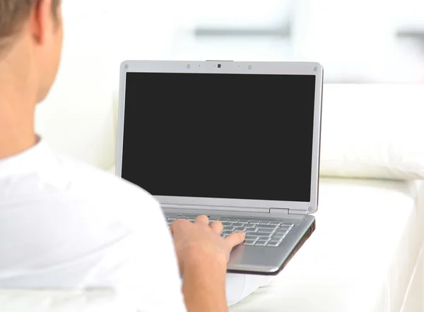 一个年轻男子的后视特写工作的一台笔记本电脑 — 图库照片