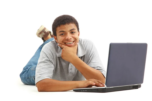 Gelukkig jonge man aan het werk op een laptop, geïsoleerd tegen witte achtergrond — Stockfoto