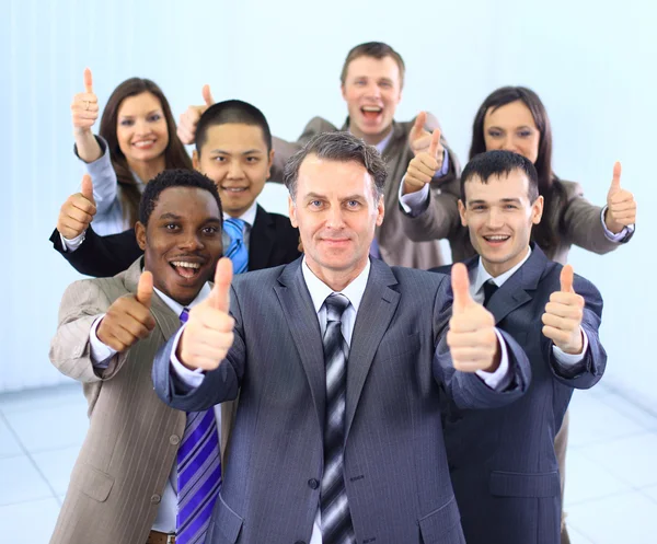 Equipe de negócios multi-étnica feliz com polegares no escritório — Fotografia de Stock