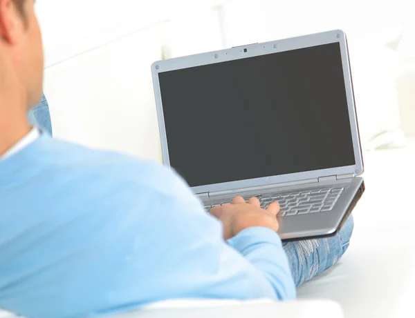 Man ontspannen met zijn laptop op een bank — Stockfoto