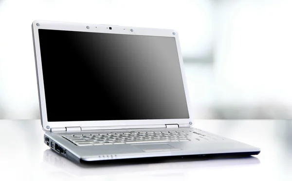 유리 테이블에 대 한 고찰과 흰색 절연 현대 노트북. — 스톡 사진