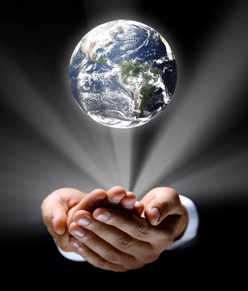 Un homme tenant dans ses mains un globe terrestre rayonnant — Photo