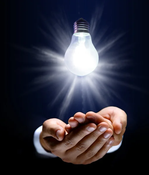 Glowing lightbulb and hand Stock Photo
