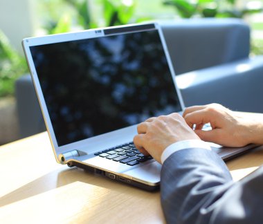 Person Typing on a modern laptop in an office clipart