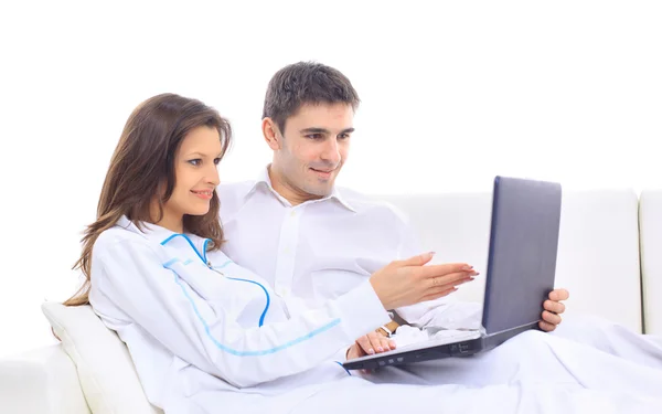 Junges Paar schaut auf Laptop auf Sofa — Stockfoto