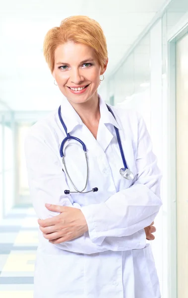 Atractiva doctora en bata blanca con estetoscopio alrededor de los hombros —  Fotos de Stock