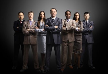 Business team formed of young businessmen standing over a dark background