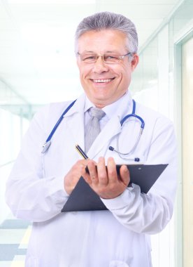 Closeup portrait of a happy young doctor with stethoscope in hospital writi clipart