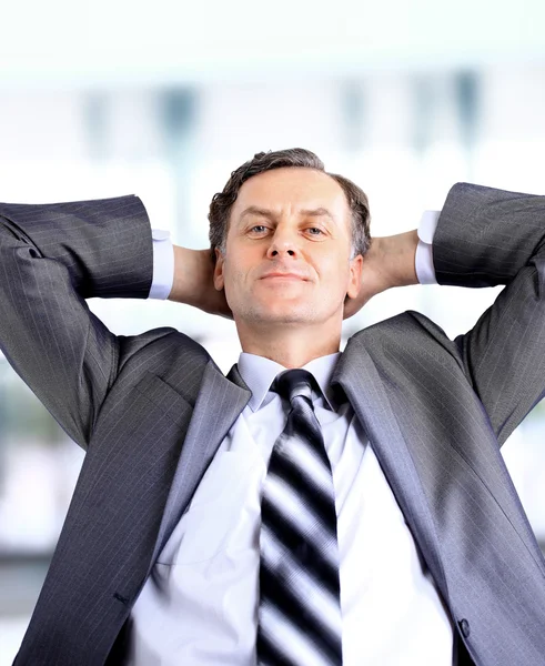 Relaxado e sonhando homem de negócios senta-se na cadeira de escritório — Fotografia de Stock