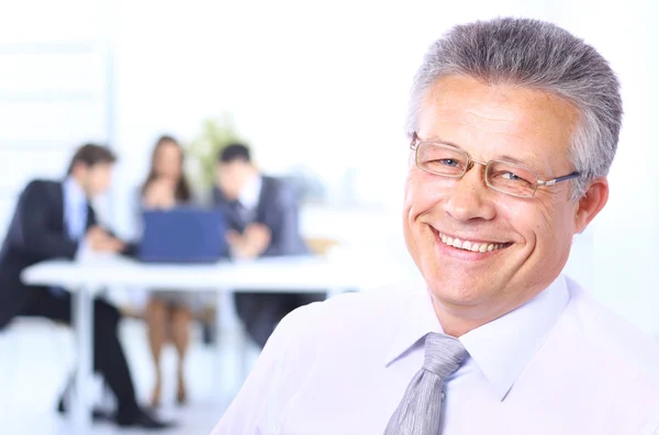 Porträtt av en säker senior business man vid mötet kolleger sitter en — Stockfoto