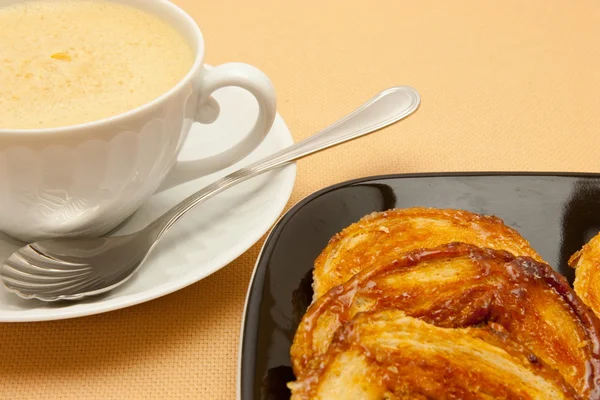 Closeup of coffee with milk in white cup and a palmier pastry — Stock Photo, Image