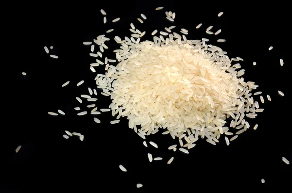 Hromadu dlouhozrnné rýže na černém pozadí — Stock fotografie
