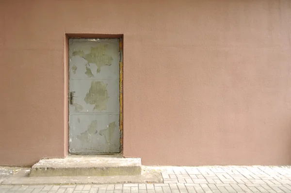 Бетонная стена со старой дверью — стоковое фото