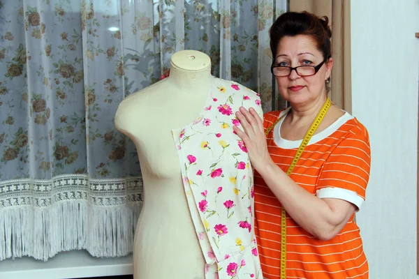 Oude vrouw naait kleren in-home — Stockfoto