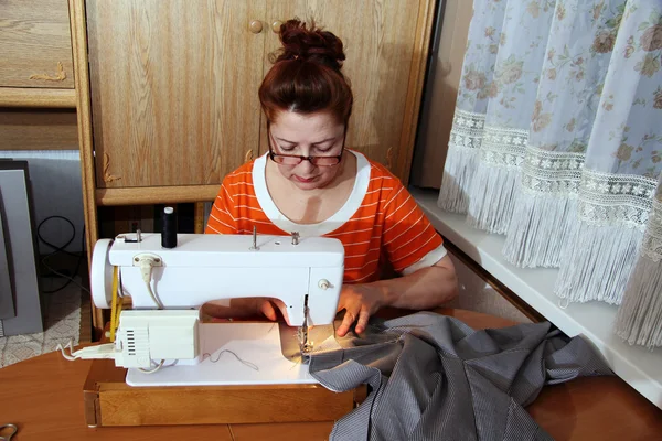 Vecchia donna cuce i vestiti in casa — Foto Stock
