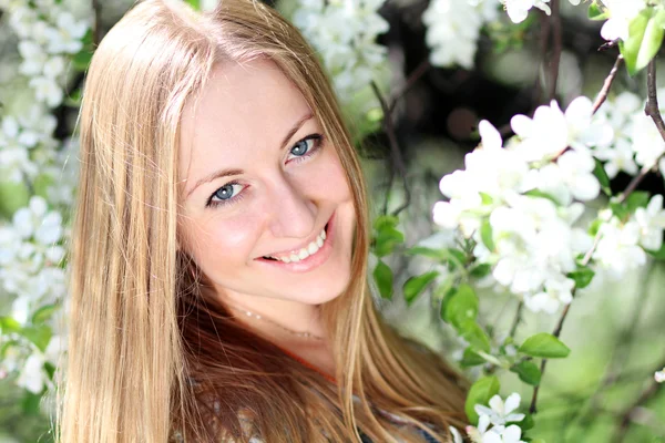 Mooi blond meisje in de lente cherry tuin — Stockfoto