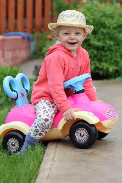 Маленькая девочка играет с автомобильной игрушкой — стоковое фото