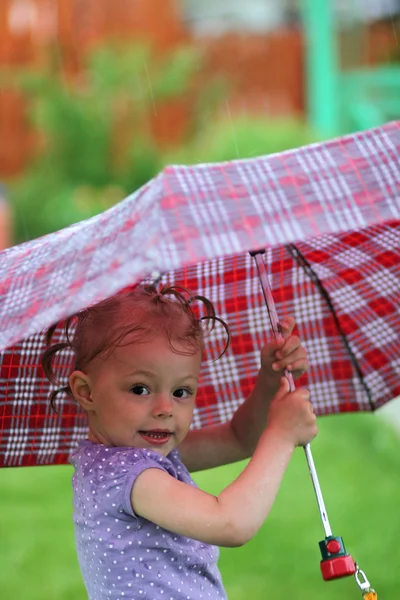 Kleines Mädchen mit Regenschirm im Park — Stockfoto
