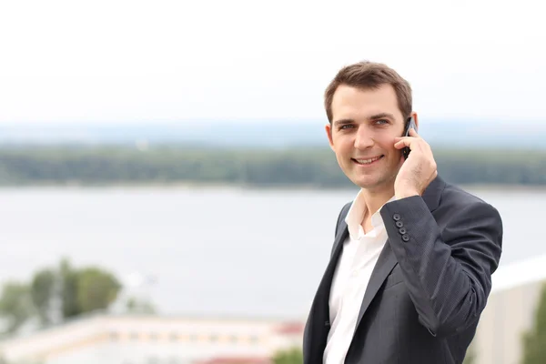 Молодий чоловік з мобільним телефоном на відкритому повітрі — стокове фото