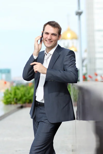 Νεαρός άνδρας με κινητό τηλέφωνο σε εξωτερικούς χώρους — Φωτογραφία Αρχείου