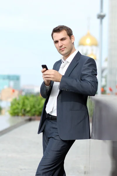 Молодой человек с мобильным телефоном на улице — стоковое фото