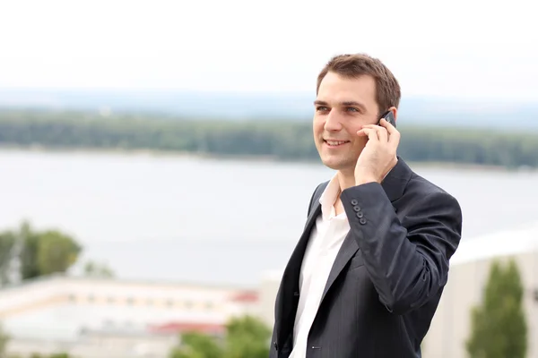 Молодий чоловік з мобільним телефоном на відкритому повітрі — стокове фото