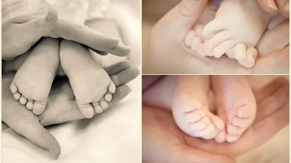 Les jambes du bébé dans les mains de la mère — Photo