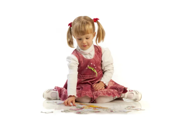 Small girl collecting a puzzle — Stock Photo, Image