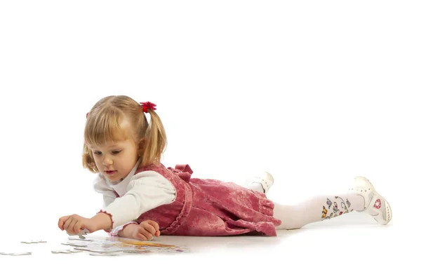 Klein meisje verzamelen een puzzel — Stockfoto