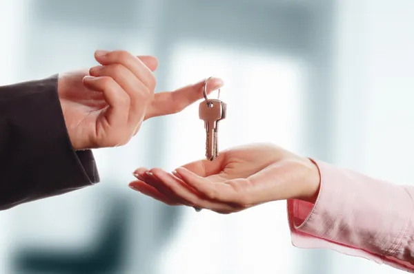 Homem entregando a uma mulher um conjunto de chaves — Fotografia de Stock