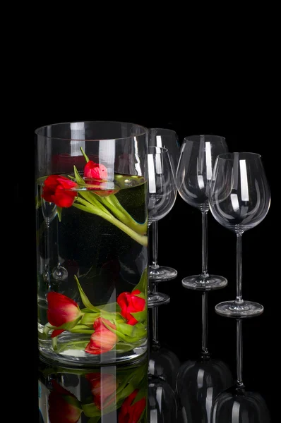 Tulipány v poháru s brýlemi — Stock fotografie