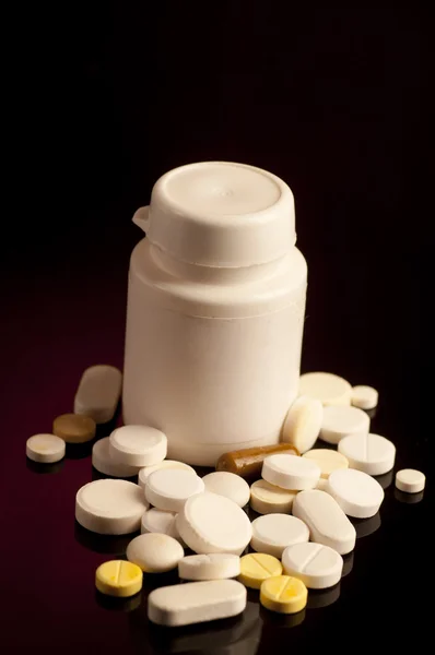 Pill bottle with medicine spilling — Stock Photo, Image