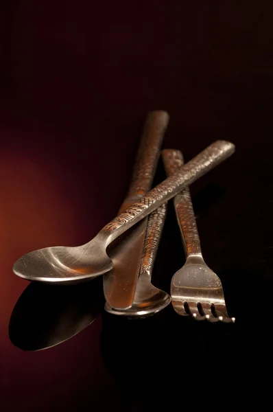 Fourchette, couteau et cuillère argentés sur fond noir — Photo